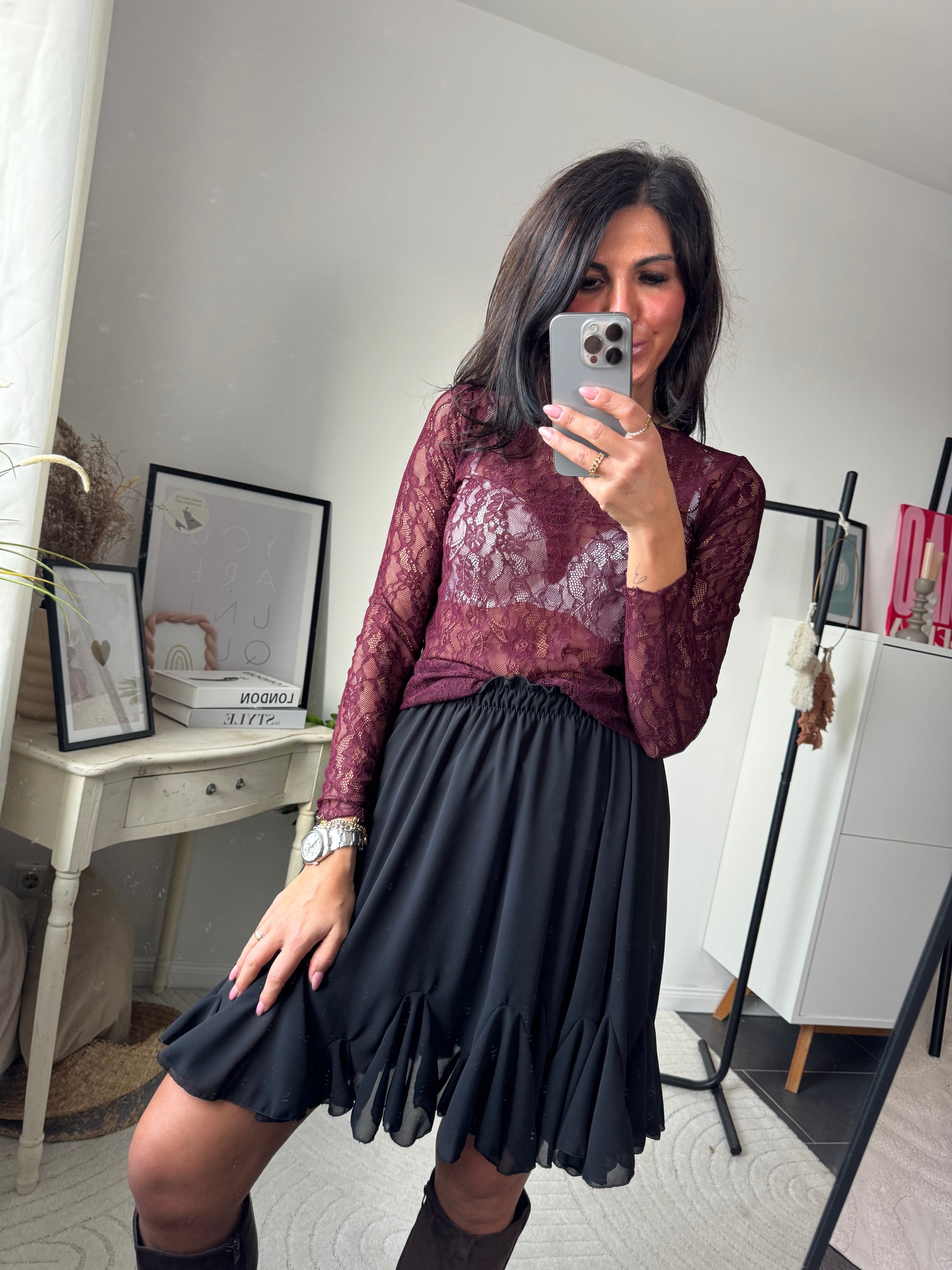 Weinrote Spitzenbluse und schwarzer knielanger Rock 